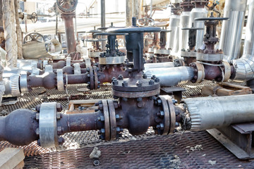 Fototapeta na wymiar Old pipelines made of steel chromemolybdenum and valves on the service platform