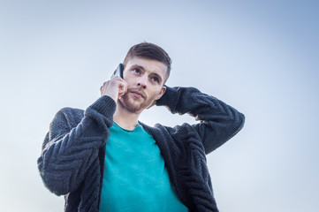 the young man speaks by phone having thrown a hand for the head. concept mobile communication