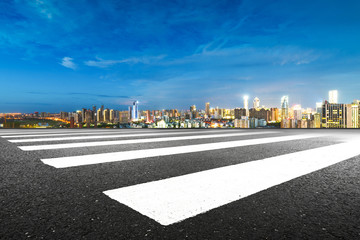 Obraz premium empty asphalt road and cityscape of Nanchang in blue sky at dawn