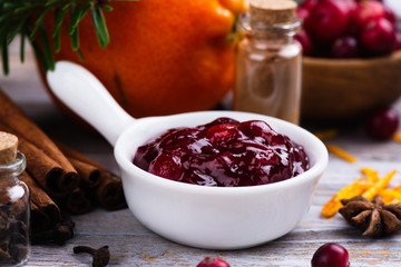 Cranberry sauce with ingredients on wooden table. Space for text