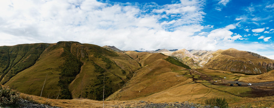 Panorama of Caucasian mountains near Gergeti Trinity Church, village of Gergeti and Stepancminda in Georgia.