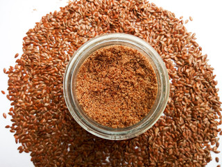 High angle shot of Flaxseeds and grounded seeds in jar