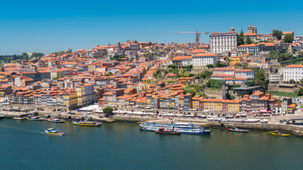 Fototapeta na wymiar Orange tiles roofs in Porto, Portugal, panorama with typical houses on the hill 