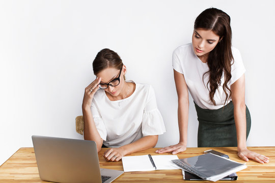 Busy women dressed in office style look thoughtful sitting at the laptop