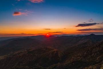 Sunset over mountain hills, aerial panoramic view