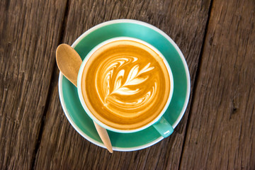 Cup of coffee on old wooden desk table background.