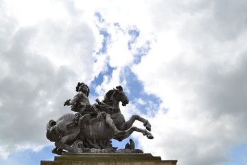 Dramatic view of King Louis XIV Statue, against cloudy sky, in Paris, in 1st Arrondissement, near Louvre Museum, France