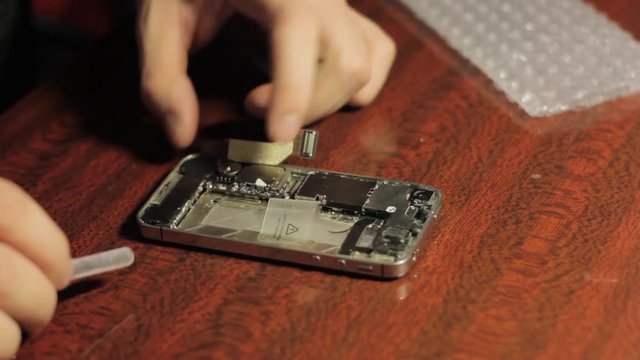 Electronics repair. Master repairs cell phone. The internal components of a smartphone