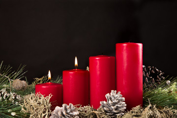 red advent candles with green pir and pinecone