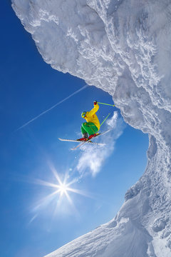 Skier jumping against blue sky from the rock