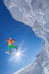 Skier jumping against blue sky from the rock