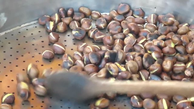 mano che gira le castagne arrosto