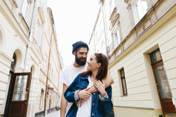 Man hugs woman from behind standing with her on the street