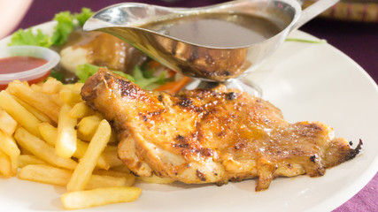 chicken grill set with black pepper sauce,potatoes fries and salad on white plate