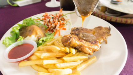 chicken grill set with black pepper sauce,potatoes fries and salad on white plate