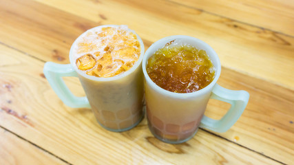 Iced tea with milk and plain iced tea  on wooden background