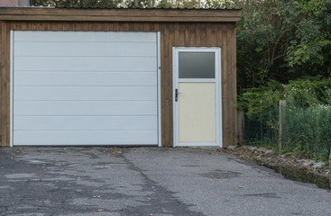 Obraz na płótnie Canvas Weißes Garagentor und weiße Tür einer Garage