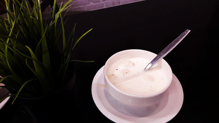 Cream soup in white cup on  table background with space for text here