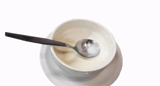 Cream soup in white cup after eating on white background with space for text here.