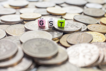 The word GST (Goods and services tax) over coins background