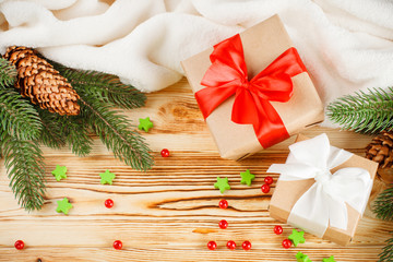 Craft gift boxes with color ribbon and bow, green Christmas tree, decorations, white plaid on wooden background. Xmas and New Year congratulation card, banner, flyer.