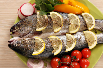 two trout fish with vegetables on plate