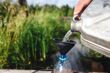 Pouring gasoline through funnel in bottle