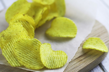 Potato chips on a wooden tray