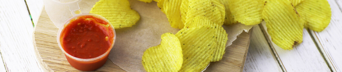 Horizontal bakground of potato chips on a table