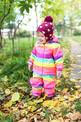 Smiling happy 1 year little girl walking in autumn outdoors