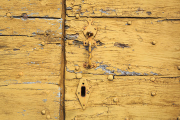 SAINT-LEONARD-DE-NOBLAT, FRANCE - 22 JULY, 2017: Detail of old and distressed wooden planks, with weathered yellow paint.