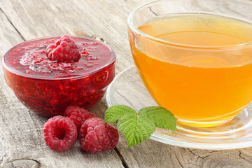 healthy food. raspberry with raspberry jam and tea on old wooden background