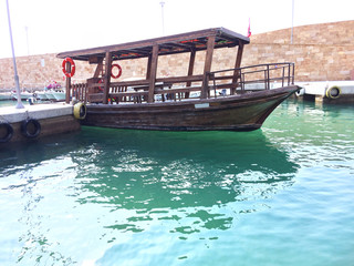 Wooden fishing boat on a green lighty water