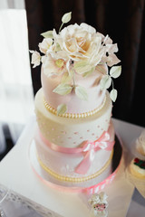 Wedding cake decorated with white rose and pink bows