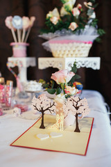Paper decoration made of wedding couple and pink trees