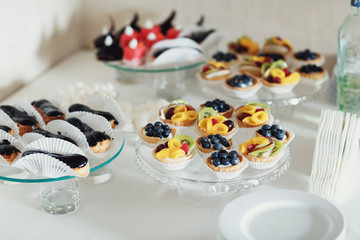Obraz na płótnie Canvas Baked baskets with fruits and berries on glass dish