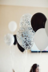 White and black balloons hang in the room
