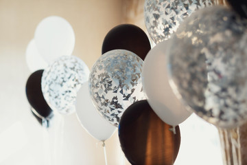 White and black balloons hang in the room