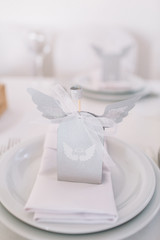 White paper box with wings stands on white dinner table