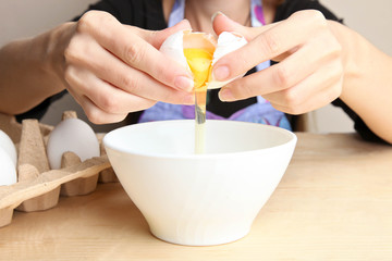 girl is breaking a chicken egg