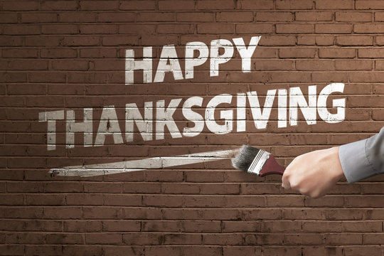 Man hand with paintbrush writing Happy Thanksgiving message