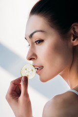 woman eating slice of cucumber