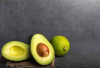 avocado with a lime on a grey stone background