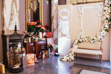 Place for photos made of cosy sofa and flower garlend hanging over it