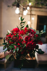 Fototapeta premium Stunning wedding bouquet made of red peonies, roses and dark green leaves