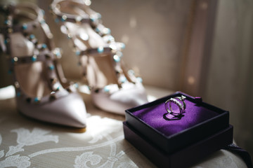 Silver wedding rings with diamonds stand in violet box