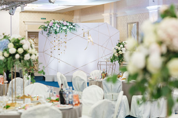 Look over dinner tables at the wall with newlyweds initials