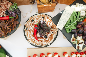 Sliced meat decorated with sweet basil and red pepper