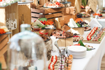 Wooden boxes with snacks stand on white dinner tables