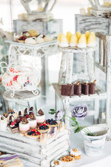 Look from above at dishes with different kinds of chocolates and cookies served on a candy bar